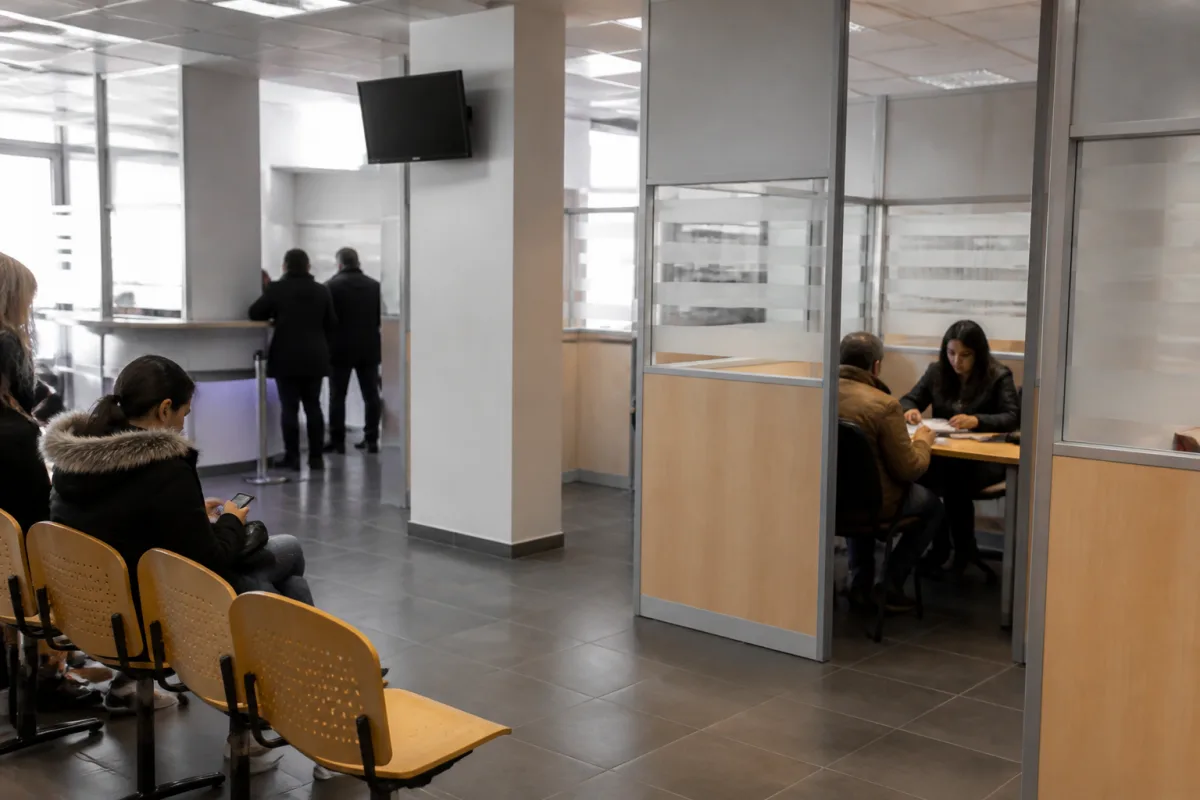 An applicant being helped at a support center while filing residency permit documents in France