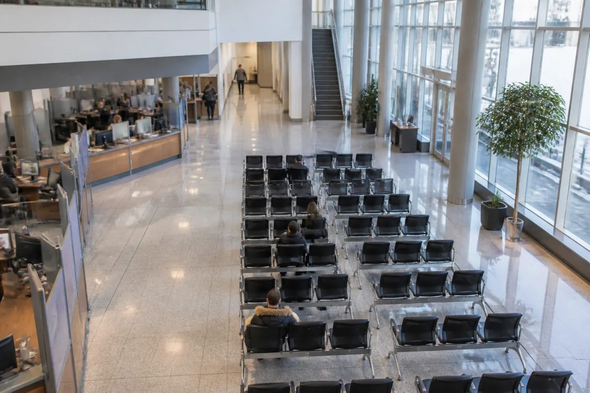 A waiting hall or office at a Canadian government facility with people in line