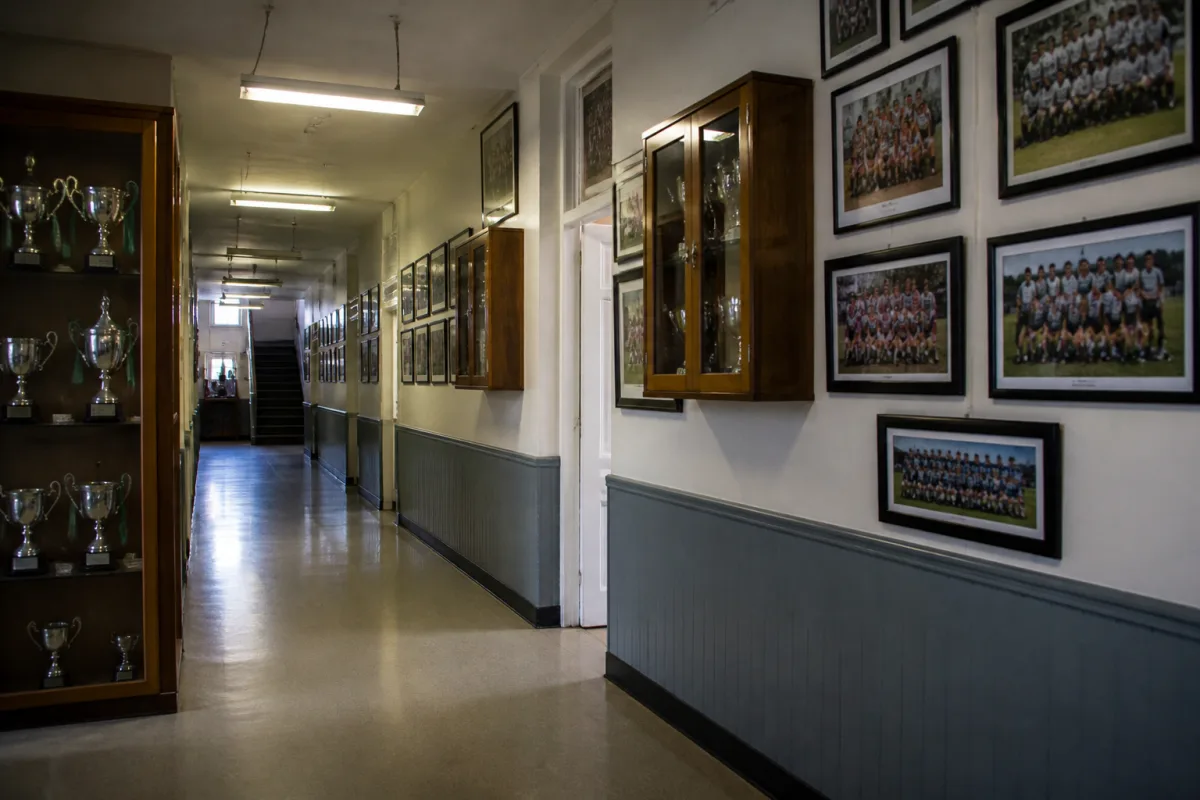 A display case with trophies and team photos in the hallway of an Irish school