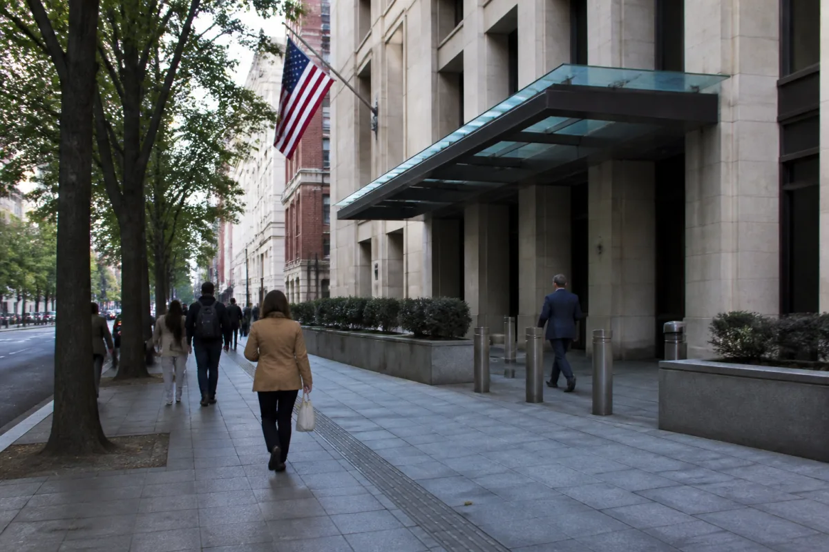 Applicant with documents at a consulate window waiting for a review of a visa denial