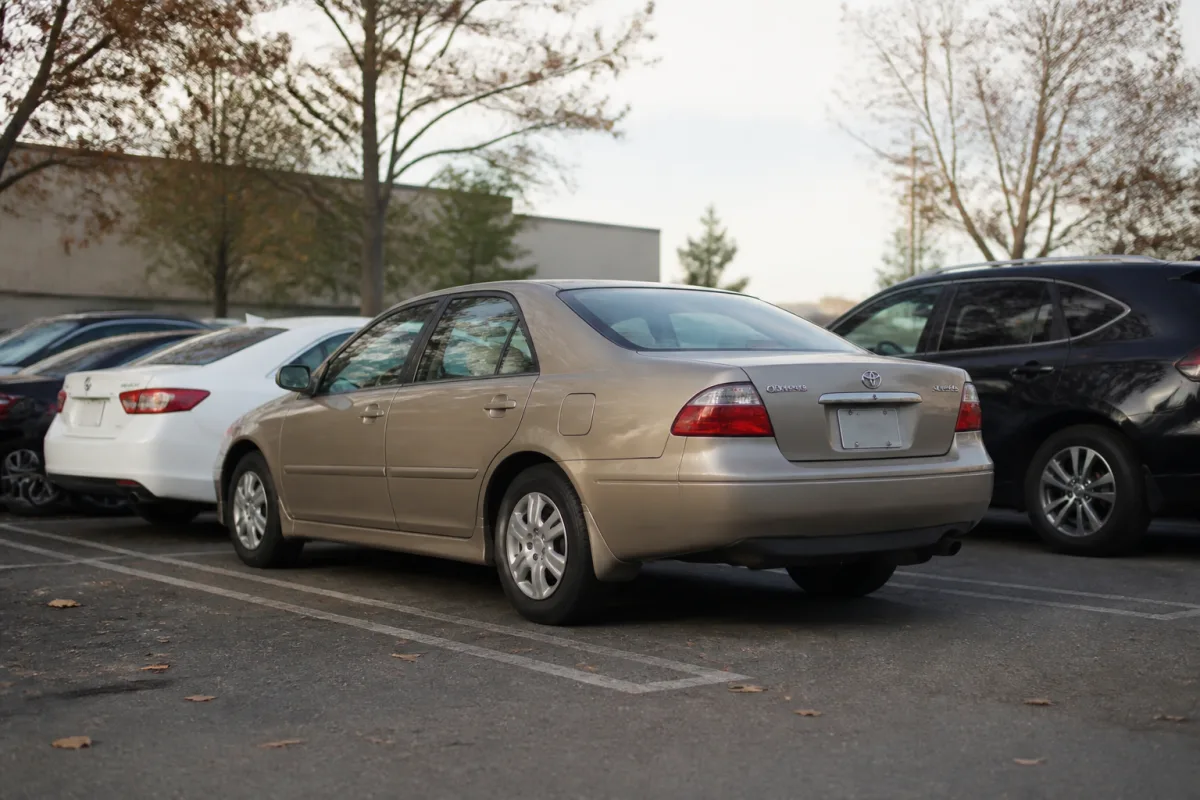 A used Toyota Camry parked outside, an example of a budget-friendly car bought without a loan