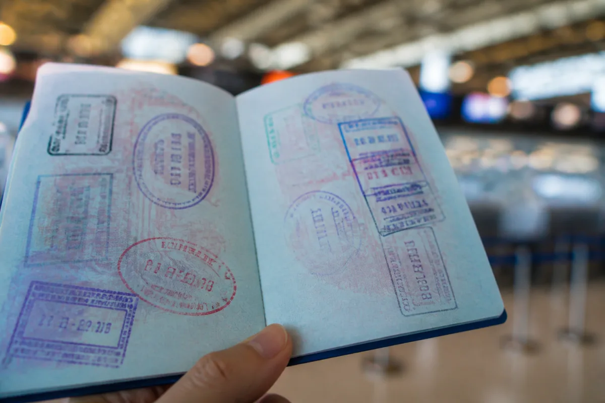 Visa stamps and travel entries in a passport for the DS-260 visa history section
